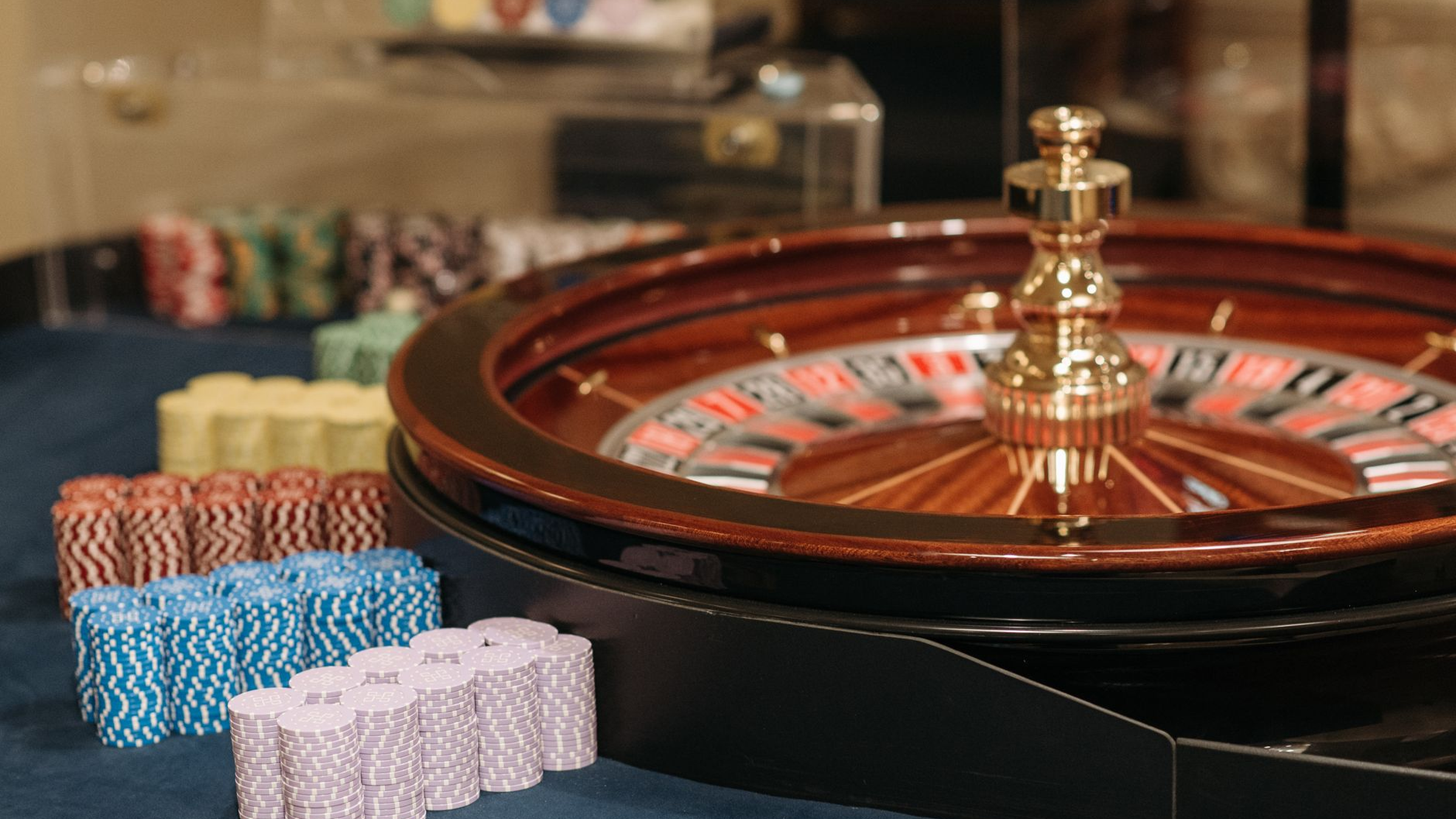 Adult guests in evening dress around a casino-themed table in a low-lit private salon