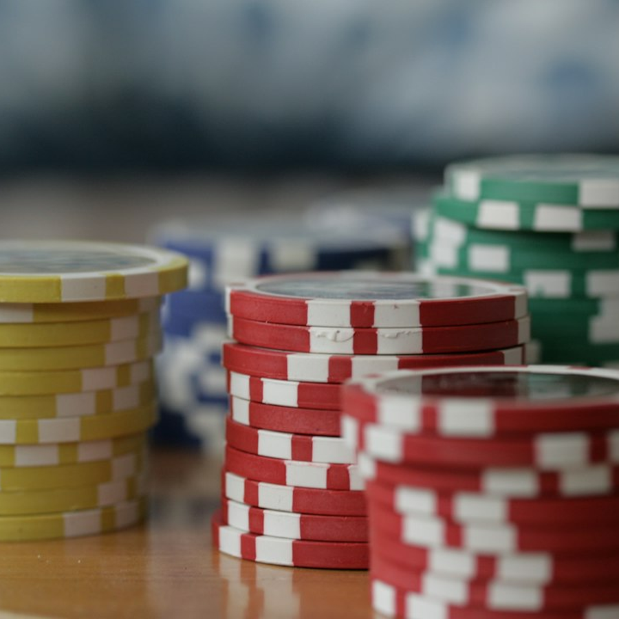 Close detail of unmarked symbolic chips stacked in neat columns on dark felt